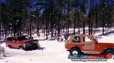 Red 1978 Ford Bronco stuck in snow, front bumper visible