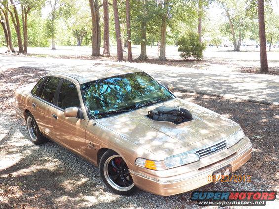 1993 Ford Crown Victoria with custom hood scoop exposing engine intake, gold paint, aftermarket wheels