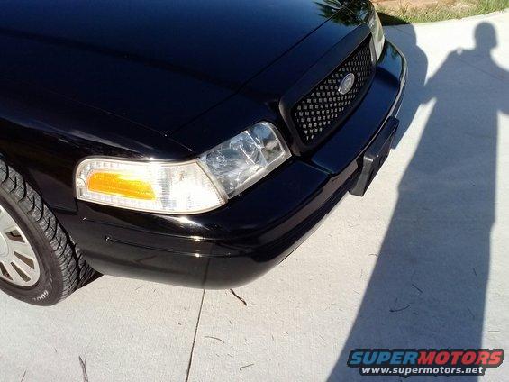 Black Ford Crown Victoria front bumper and headlight assembly, angled view