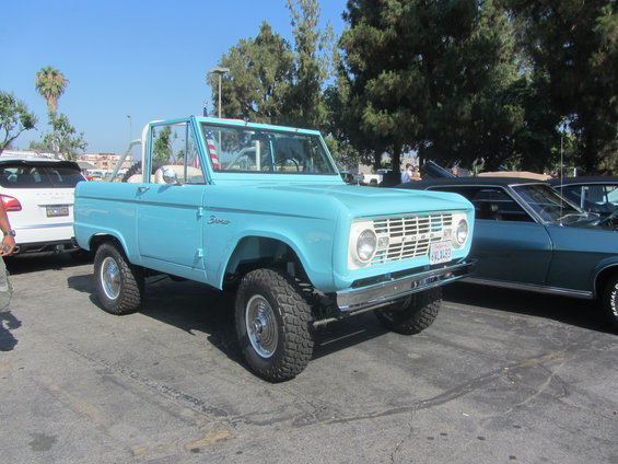 Light blue first-generation Ford Bronco with aftermarket wheels and tires. License plate reads 6VLJ183