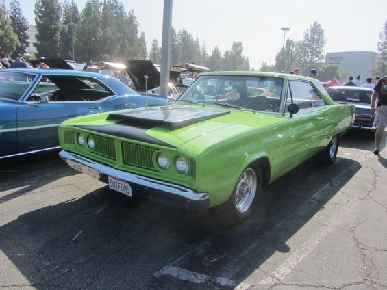 Lime green 1966 Dodge Coronet with black hood scoop parked next to a blue car