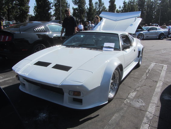 White De Tomaso Pantera with hood and trunk open, parked next to black Ford Mustang