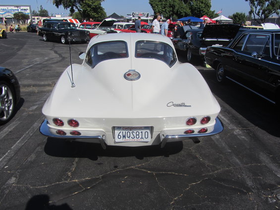 White 1963 Chevrolet Corvette Sting Ray rear view, California license plate 6WQS810. Other cars visible in background