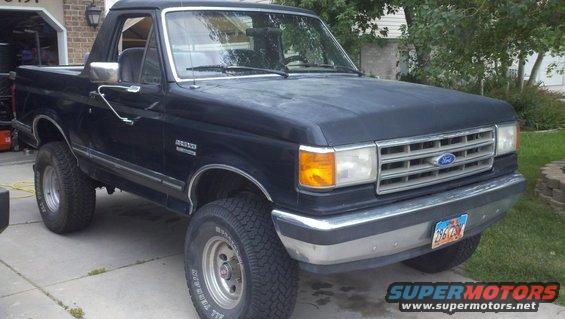Black Ford Bronco parked in a driveway. Has a removable top