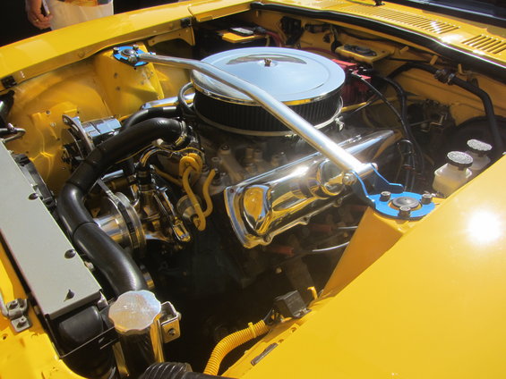 Yellow engine bay with chrome air cleaner, V8 engine, and blue strut tower brace
