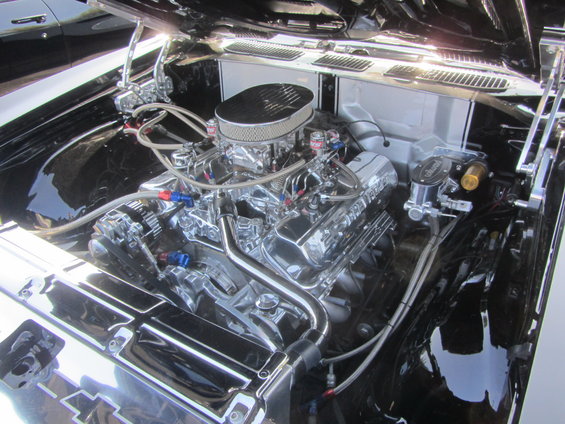 Engine bay with a shiny V8 engine, chrome air cleaner, and braided hoses
