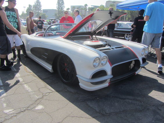 White 1958 Chevrolet Corvette convertible with black and red accents, hood open, parked outdoors