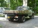 1979 Ford Bronco - This 1979 Ford F-250 flatbed truck features a custom wooden bed and is parked next to another vehicle in a wooded area.