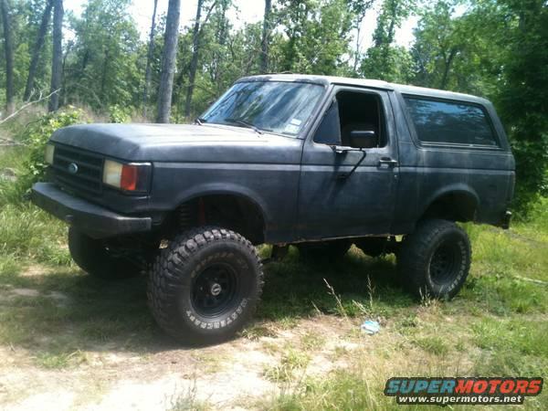 1990 Ford Bronco parked in a wooded area