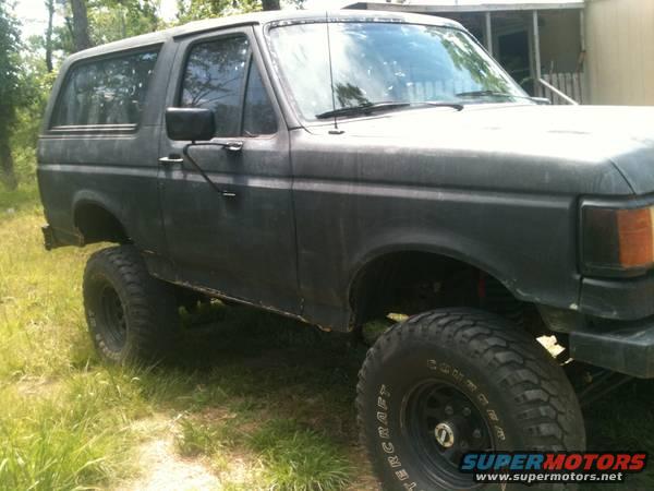 Side view of a dark-colored Ford Bronco with lifted suspension and large tires