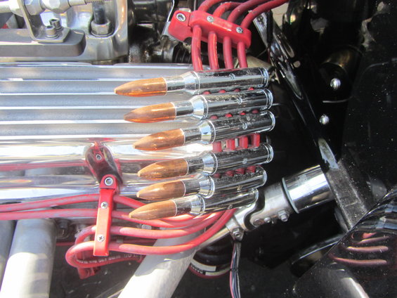 Engine bay detail showing chrome spark plug wire holders shaped like bullets