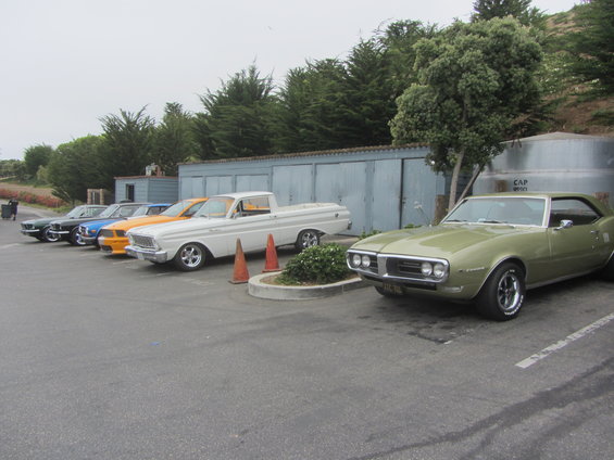 Green 1967 Firebird parked in front of a line of classic cars including a white Ford Ranchero