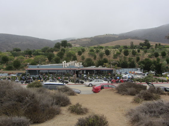 Neptune's Net restaurant parking lot filled with motorcycles and cars on a cloudy day