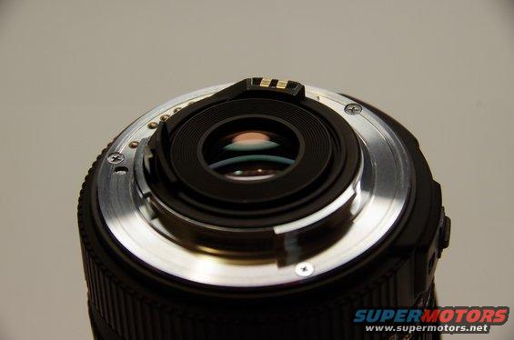 Camera lens mount with electrical contacts and screws, viewed from the rear