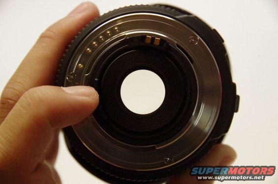 Close-up of camera lens mount with hand holding it