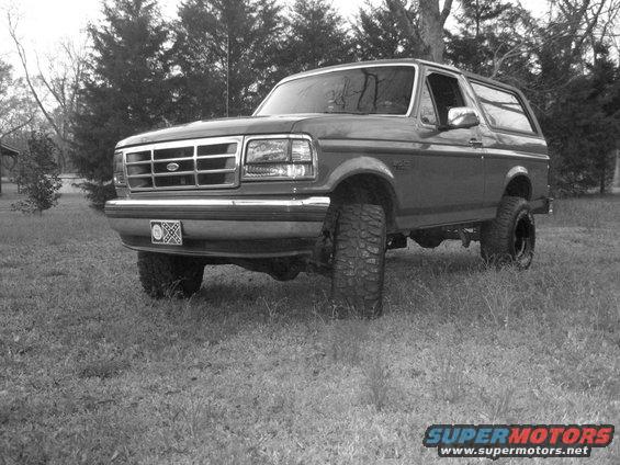 1992 Ford Bronco parked in a grassy area with trees in the background