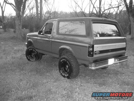 1992 Ford Bronco lifted with off-road tires, viewed from the rear 3/4 angle