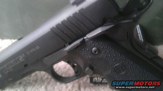 Black pistol with textured grip, slide serrations, and visible text on the frame