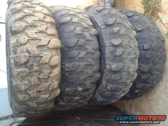Four off-road tires with aggressive tread patterns