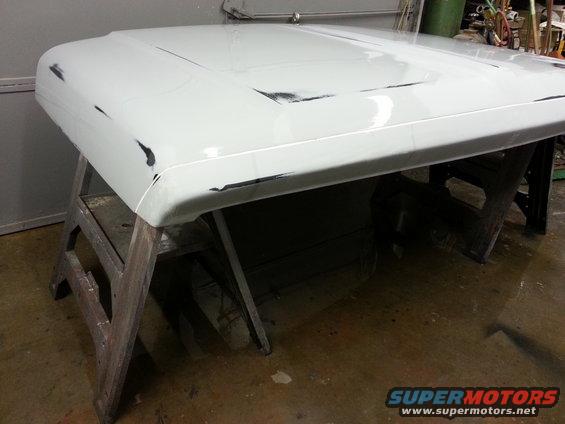 White truck hood on sawhorses, showing primer and some black areas