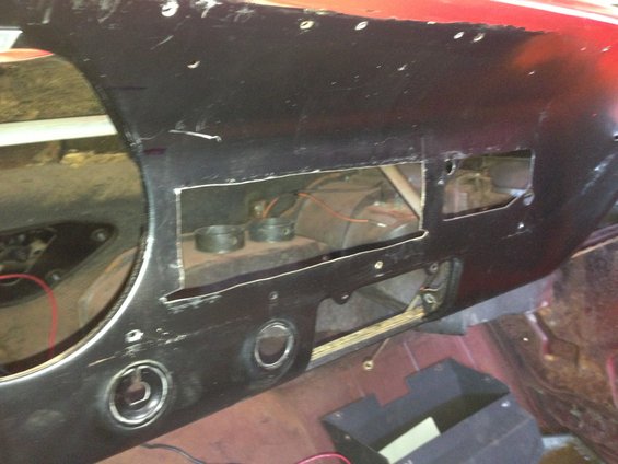 Dashboard of a car with cutouts for radio and gauges. Wires and heater core visible