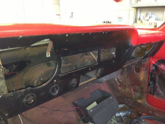 Red dashboard interior with black trim and exposed wiring