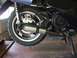 2008 Yamaha Zuma - Close-up view of a scooter's exhaust system and rear wheel, showing the muffler and brake components.