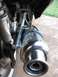 2008 Yamaha Zuma - A detailed view of a motorcycle's exhaust system, focusing on the muffler and rear wheel assembly.