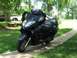 2008 Yamaha Zuma - A dark blue scooter is parked on a concrete path next to a grassy lawn.