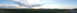 1994 Ford Bronco - A wide, panoramic view captures a rural landscape under a dramatic sunset sky, with a road leading towards distant hills.