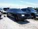 1999 Mercury Grand Marquis - Several cars, including a 1999 Mercury Grand Marquis, sit in a junkyard with their wheels removed.