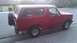 1988 Ford Bronco - This red SUV, likely a 1992 model, is viewed from the side with a spare tire mounted on the rear.