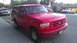 1988 Ford Bronco - This red Ford Bronco, likely a 1992 model based on its grille, is parked curbside. Another SUV is visible in the background.