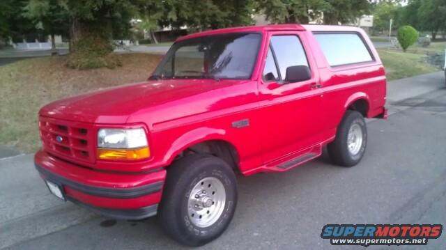 Red Ford Bronco parked on street, front 3/4 view
