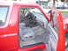 1988 Ford Bronco - Interior of a red Ford Bronco, showing the driver's seat and dashboard area.
