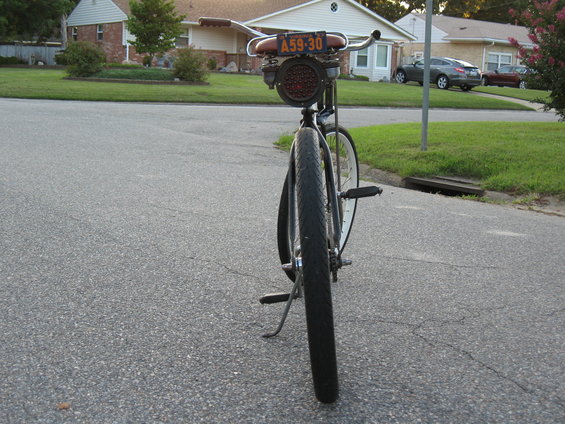 Rear view of a bicycle with a custom red taillight and a license plate reading A59-30