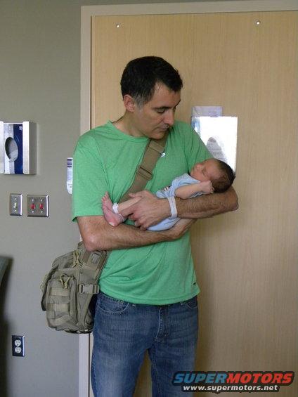 Man holding a newborn baby in a hospital room