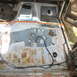 1995 Ford Bronco - The interior of a vehicle stripped down to its floor panels, revealing rust and exposed wiring.