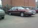 1992 Ford Crown Victoria - A maroon 1992 Ford Crown Victoria is seen parked next to another vehicle.