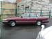 1992 Ford Crown Victoria - Maroon 1992 Ford Crown Victoria parked next to a building with a chain-link fence.