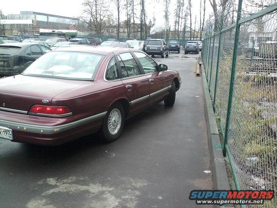 Maroon 1992 Ford Crown Victoria parked on wet asphalt, rear-left view