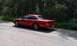 1992 Ford Crown Victoria - A red 1992 Ford Crown Victoria is parked on the side of a road with trees in the background.