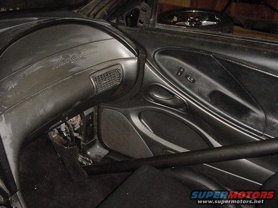 Gray dashboard with 'Mustang' script, showing exposed wiring and a roll bar