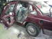1992 Ford Crown Victoria - This maroon sedan appears to be undergoing repairs or restoration, with its interior covered in protective plastic.
