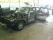 1992 Ford Crown Victoria - A maroon sedan is in a repair shop with its hood off and doors open.