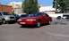 1992 Ford Crown Victoria - A red 1992 Ford Crown Victoria is parked in a lot with other vehicles under a clear sky.