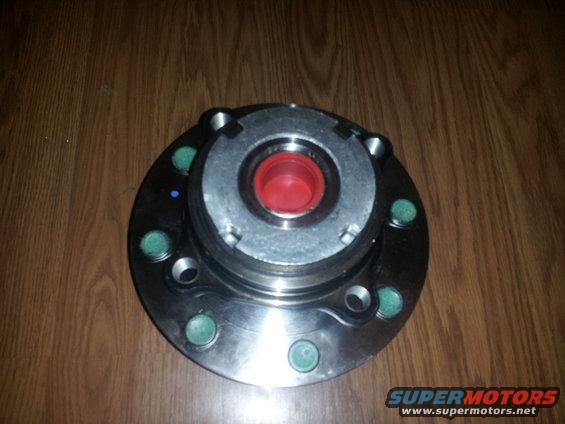 Wheel hub assembly with red center on wooden surface
