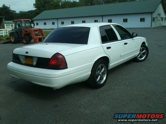 White 2004 Ford Crown Victoria sedan, rear 3/4 view, parked on asphalt