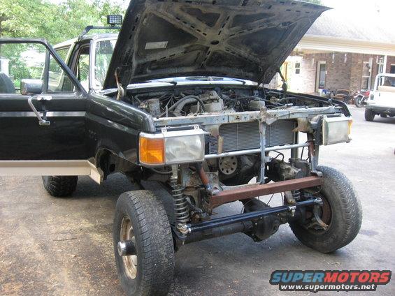 Ford Bronco with hood open, front end removed, showing engine and suspension components