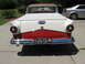 1958 Ford Ranchero - The rear of a two-tone red and white 1958 Ford Ranchero is visible, parked on a driveway next to a silver sedan.